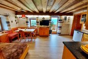Gemütliches Wohnzimmer mit Essplatz, Sofa und direktem Zugang zum großen Balkon.